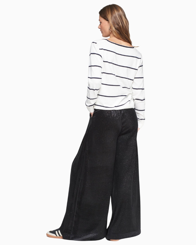 Back view showing wide-leg drape of black velvet trousers