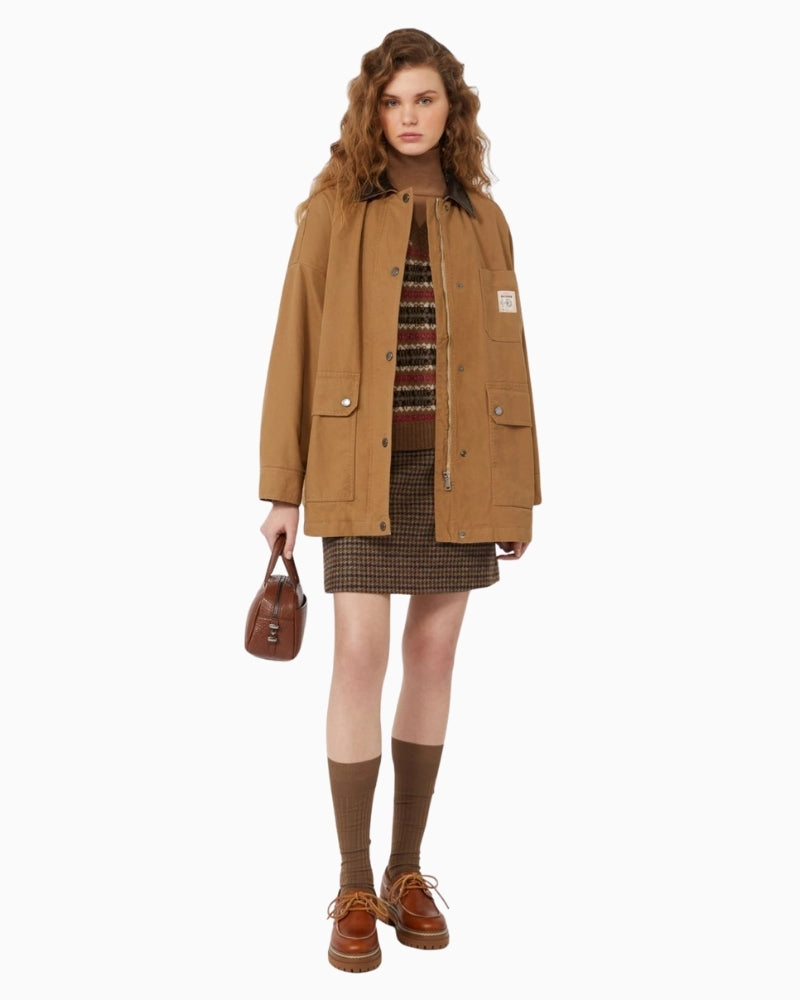 Model wearing camel gilet over white shirt styled casually with trousers