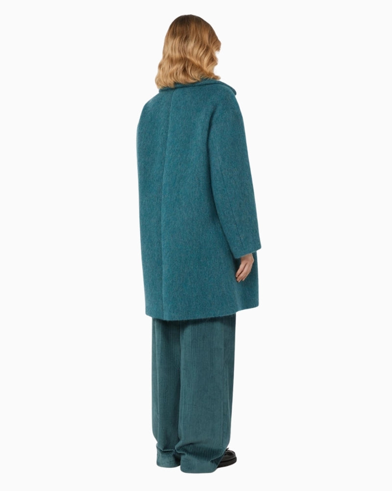 Back view of flared hem coat in soft olive-toned wool blend showing oversized cut