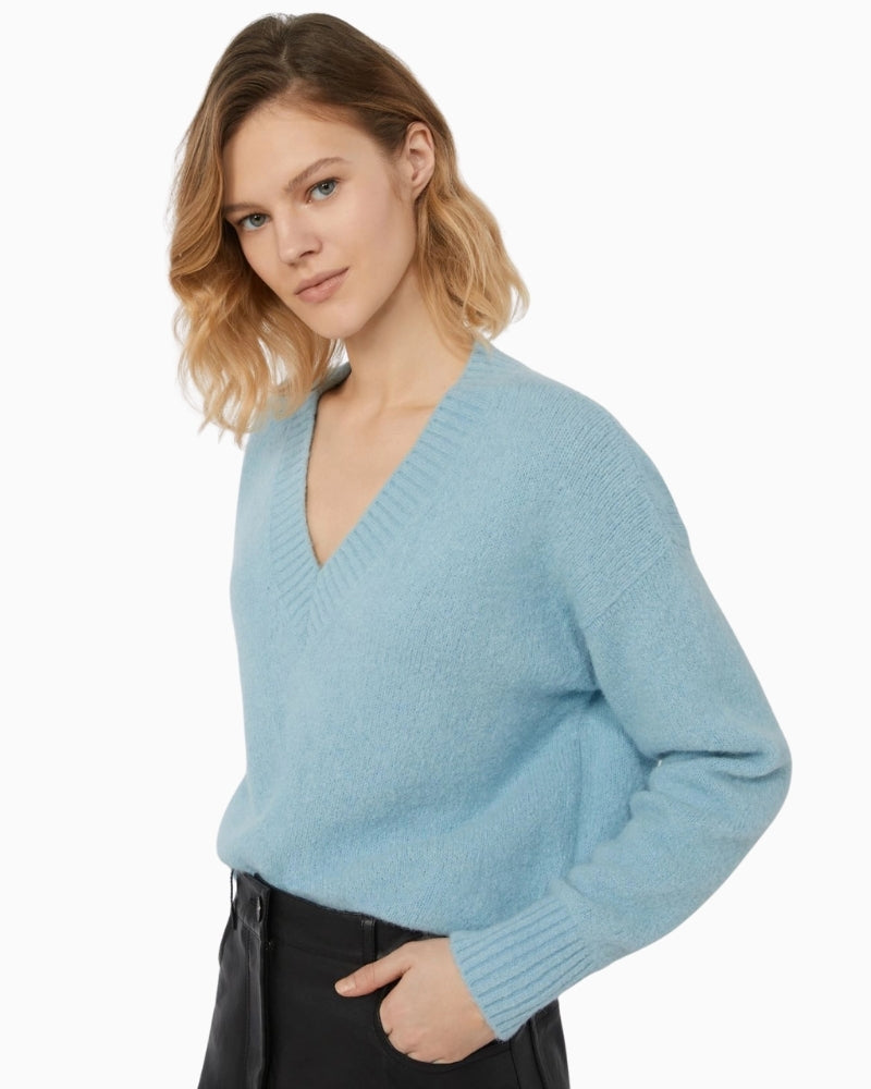 Close-up of V-neckline and soft knitted alpaca cotton blend in pale blue