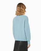 Back view of medium-length light blue jumper showing dropped shoulders and loose silhouette