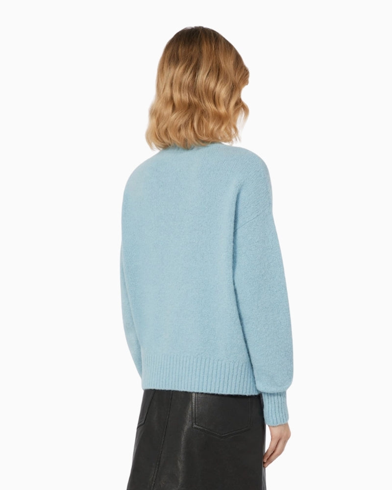 Back view of medium-length light blue jumper showing dropped shoulders and loose silhouette